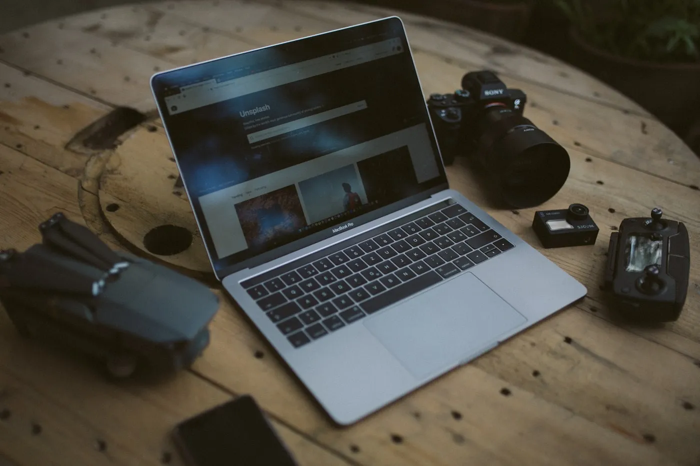 A laptop and camera on a wooden desk