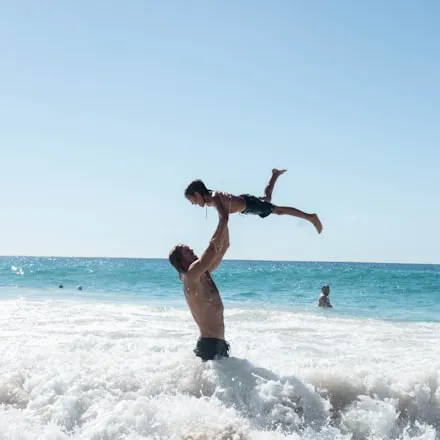 A child being lifted above the sea